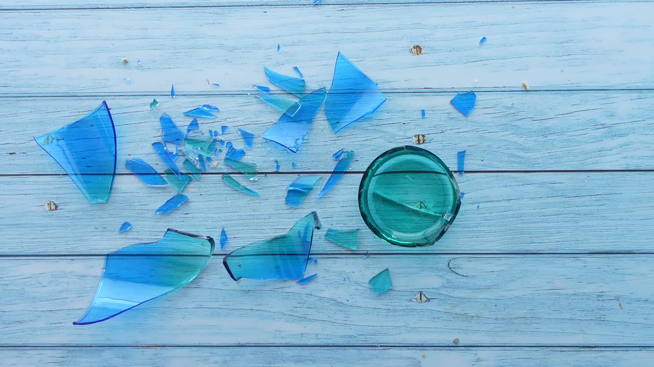 밝은 파란 나무 테이블에 깨진 파란 유리