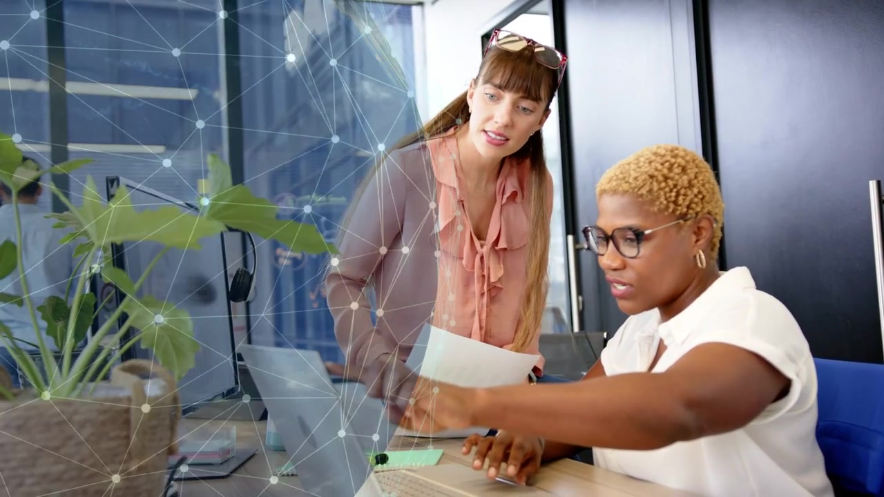 Business team reviewing laptop, standing woman showing pages, globe overlay rotating over subjects