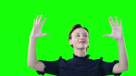 mujer caucásica levantando las manos sobre un fondo verde