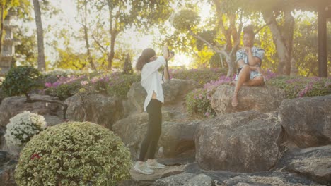 photographer taking picture of a woman model in a garden