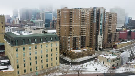 il drone vola davanti agli edifici in inverno con lo skyline nascosto dalla nebbia