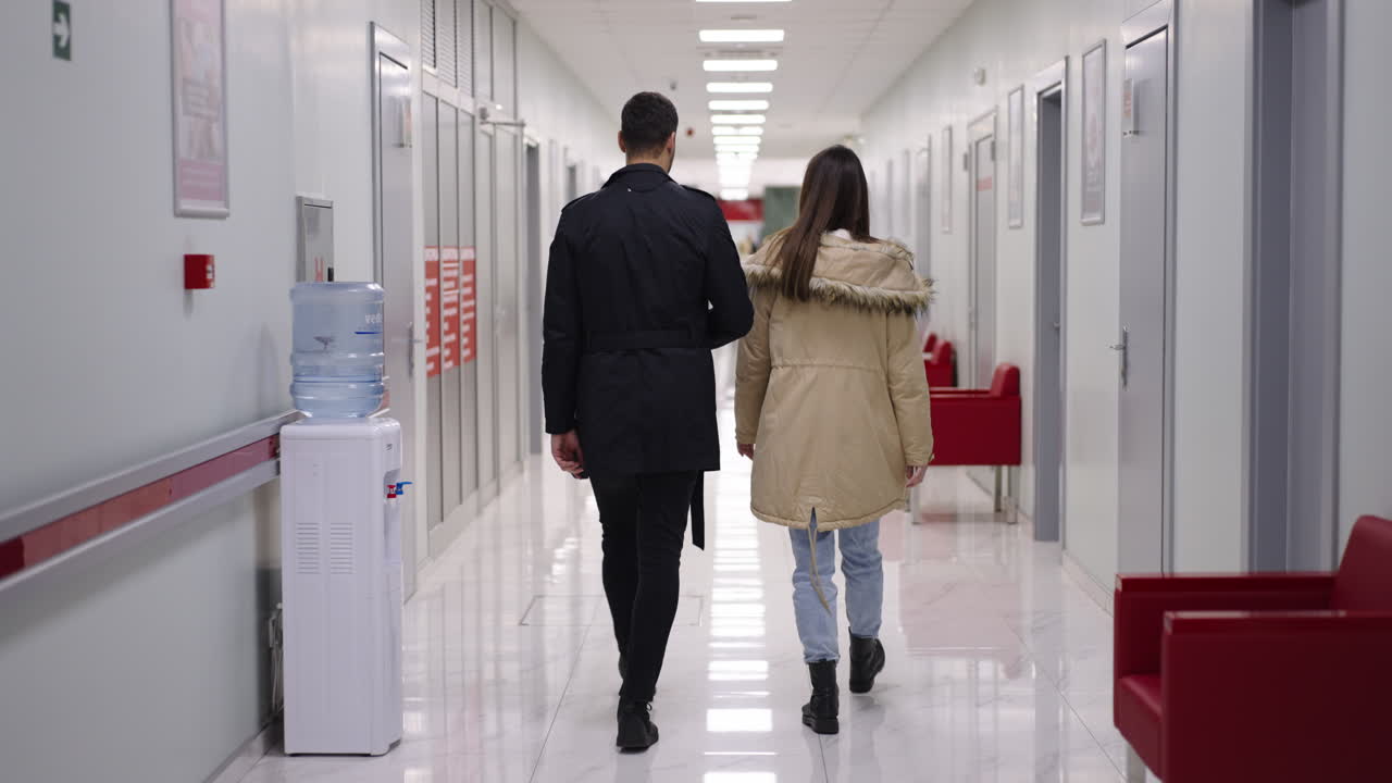 People walking down hospital hallway