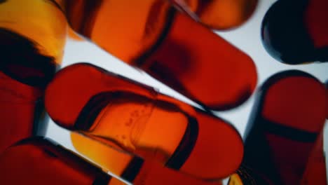 cápsulas de aceite de krill rojo cayendo hacia la cámara, llenando el marco