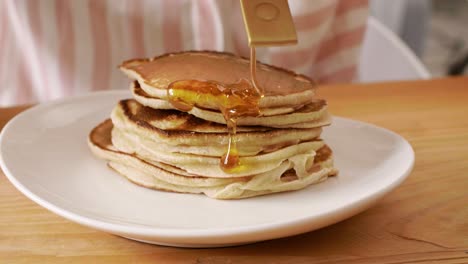 stack of pancake with honey or maple syrup