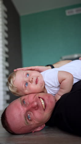 cute child with happy dad. little newborn baby with father having fun. vertical video.