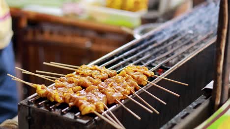 skewers being grilled at a floating market