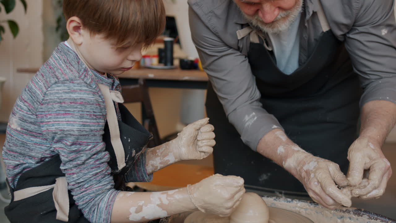 Grandfather and grandson making pottery