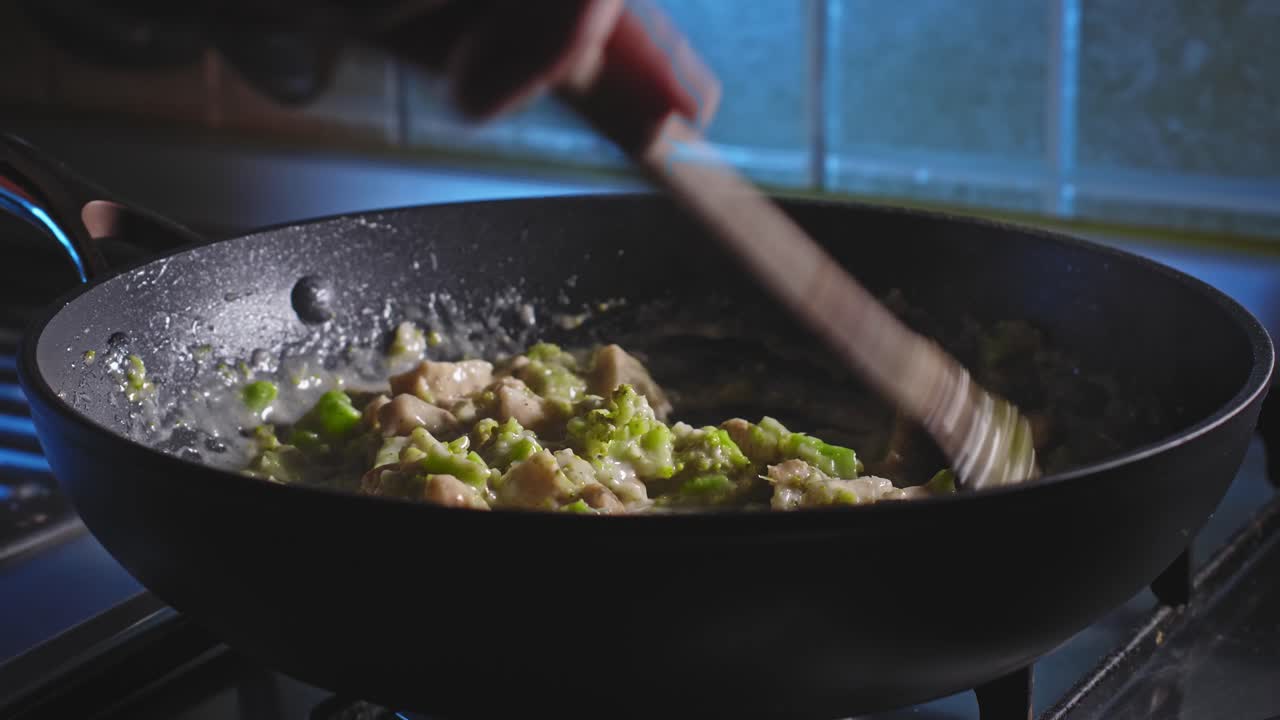 agregando pasta de espagueti cocida y escurrida sobre salsa de queso con pollo y brócoli, luego mezcle