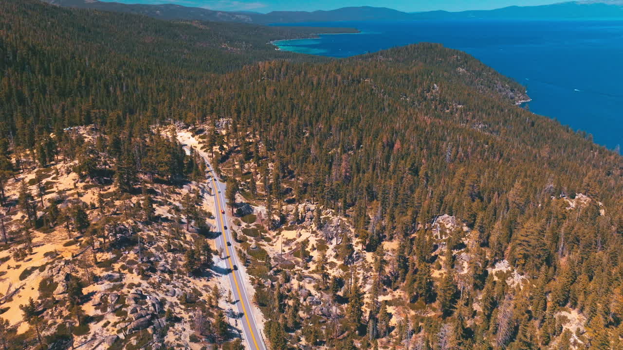 Admirable panorama of rocky land covered with pine trees. Amazing azure of Lake Tahoe on sunny hot day.