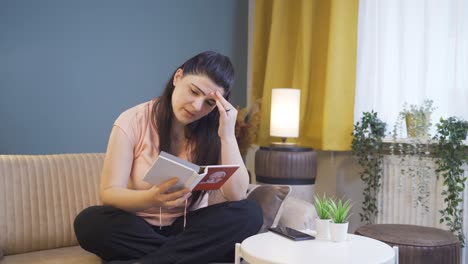 la mujer que mira el álbum de familia está deprimida.