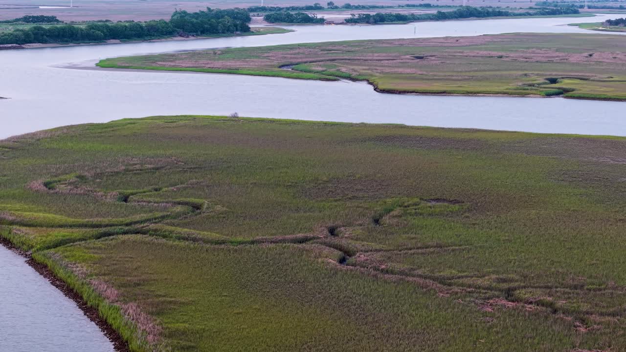 Vista aerea con drone di un fiume tortuoso e sponde erbose a Charleston, nella Carolina del Sud, che cattura le curve del corso d'acqua e il paesaggio paludoso circostante