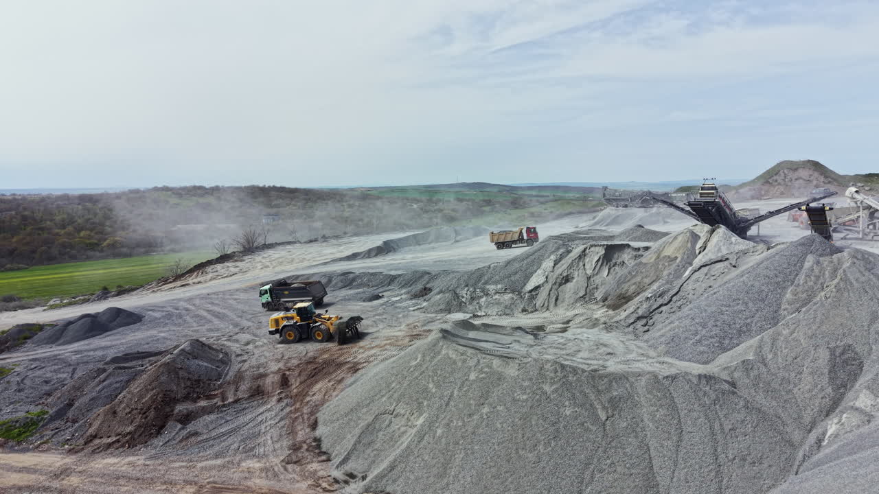 Granite quarry site with heavy machinery working on stone extraction and processing during daylight