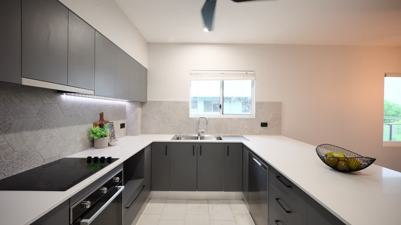 현대적인 럭셔리 회색 아파트 인테리어 부은 어두운 회색 캐비과 함께 과일 와인과 식물로 무대화되었습니다.