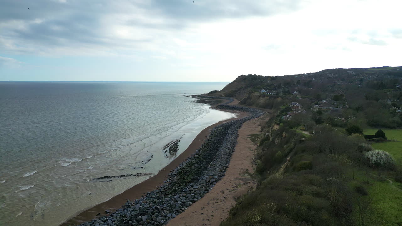 Drone glider frem og afslører barsk Fairlight Cove strand på Sussex-kysten, Storbritannien, lyst forårskystlandskab