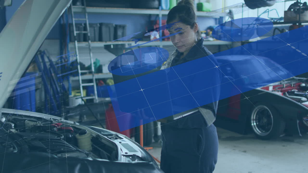 mechanic reviewing laptop diagnostics in automotive workshop, showing engine bay schematics overlay