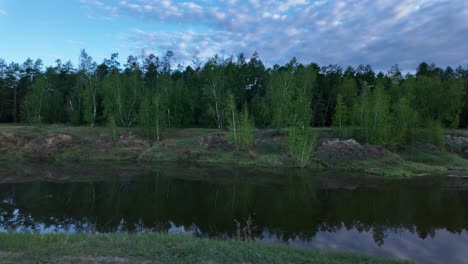 A-peaceful-pond-reflects-the-sky-at-sunrise-in-a-beautiful-forest-setting