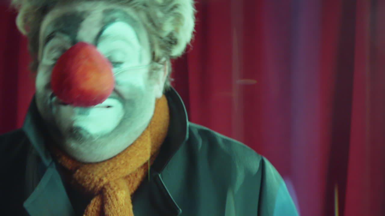 payaso gracioso haciendo caras en la cámara en el escenario