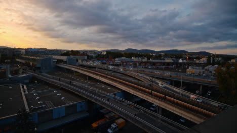 Epic-wide-angle-view-of-highway-offramp-in-Vienna-at-sunset-as-golden-hour-light-spreads-across-stormy-clouds