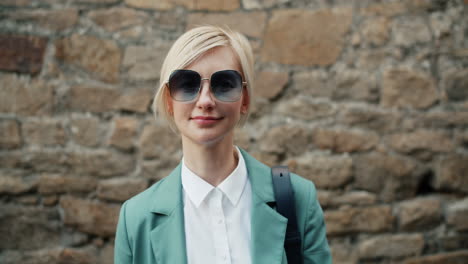 woman in green blazer and sunglasses
