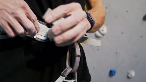 man putting on climbing harness