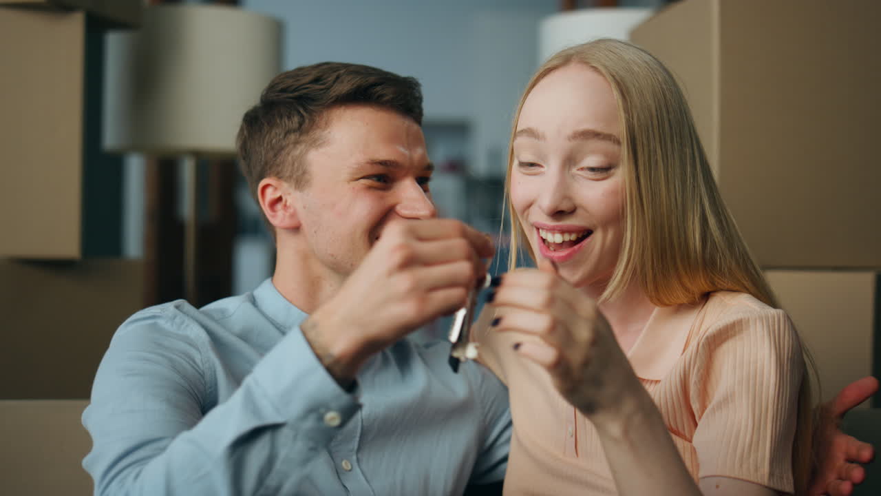 Young family happy moving in new apartment sitting surrounded boxes close up