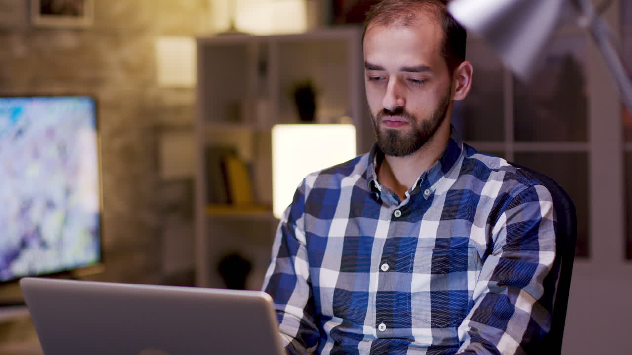 hombre trabajando en la computadora portátil por la noche