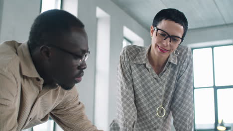 multiethnic male and female architects discussing floor plan