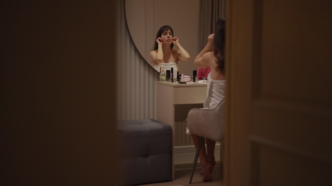 mujer aplicando maquillaje frente a un espejo