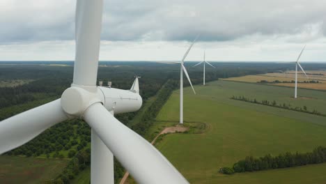 close up of a rotating wind turbine with wind turbine park in the background