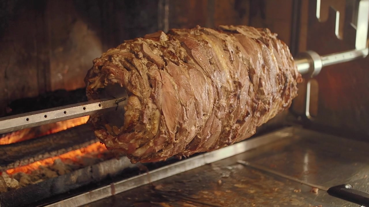 Carne per doner kebab tradizionale che arrostisce su uno spiedo verticale