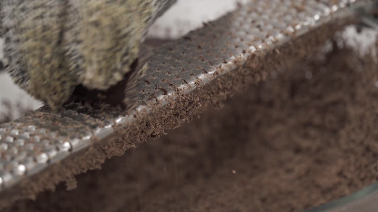 어린 소녀가 안전 장갑을 끼고 백만장자 쇼트브레드 쿠키를 만들면서 녹이기 위해 그릇에 초콜릿을 갈아넣습니다-4