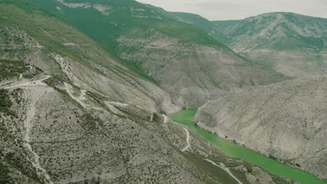 mountain valley with winding road and green lake