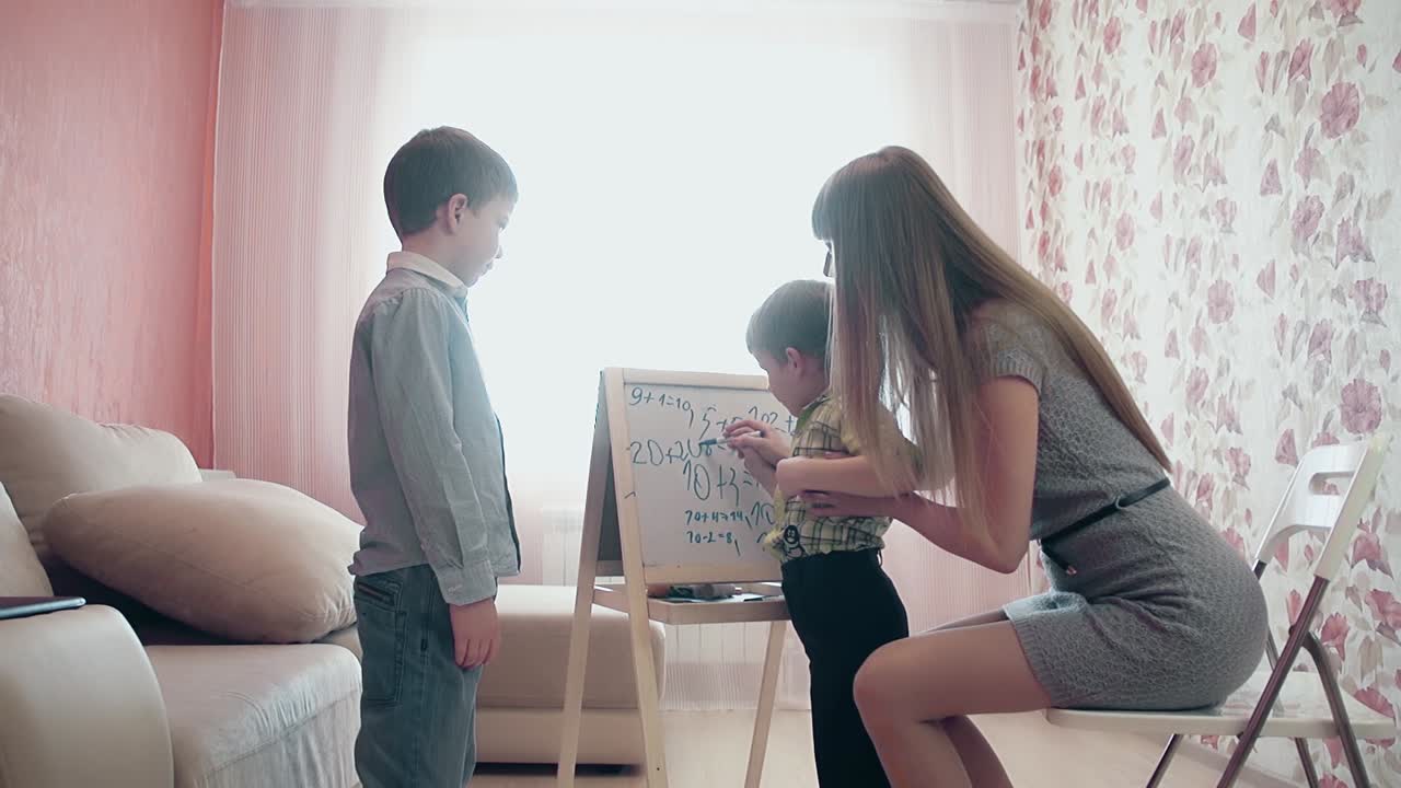 엄마는 남동생에게 숫자를 쓰는 법을 가르 ⁇ 니다.