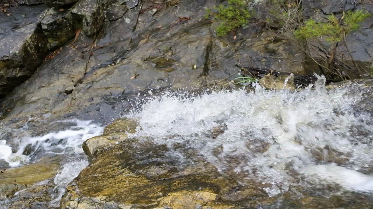 взгляд вниз на воду, каскадом стекающую по скалам на водопаде симпсон в брисбене