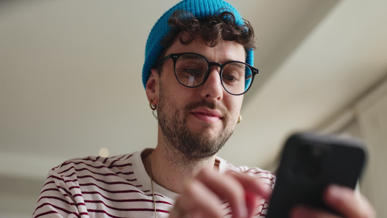 Man using smartphone with blue beanie