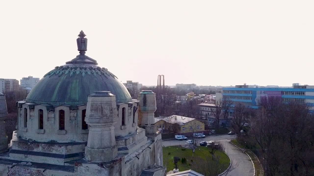 volando hacia la derecha y hacia arriba, mirando hacia un viejo edificio y luego el paisaje urbano de bucarest, rumania