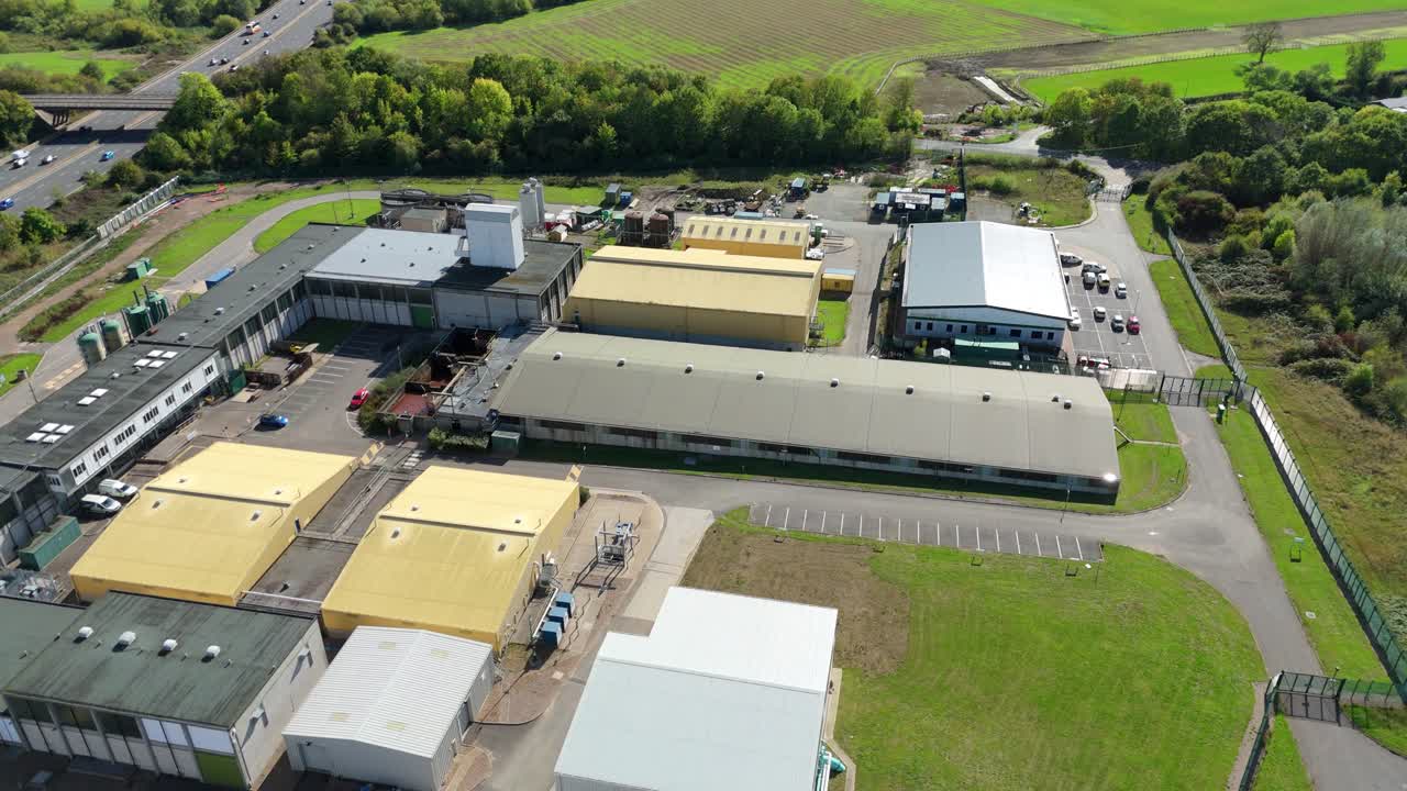 High drone sweep of sewage treatment works with aeration basins and sludge processing near Long Eaton UK