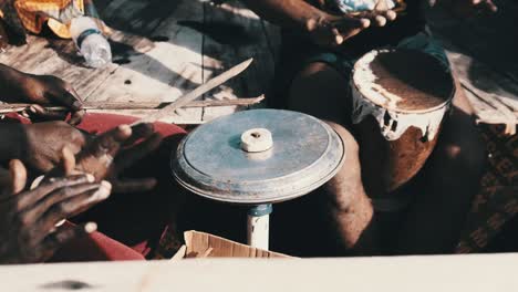 group of local africans playing drums on traditional dhow boat at trip, zanzibar