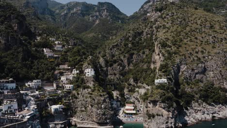 Drone-shot-lowering-to-reveal-Praiano,-Italy's-uniquely-steep-seaside