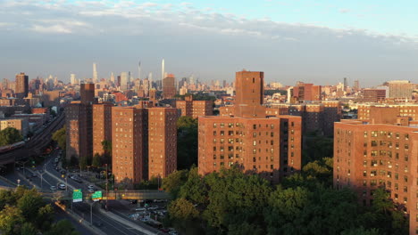 clear aerial golden hour rise over a harlem nyc public housing project revealing midtown manhattan in the distance