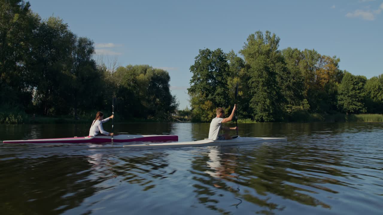 Zwei Personen, die auf einem ruhigen Fluss Kajak fahren