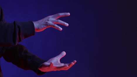 hands of asian man, touching virtual screen on blue background, copy space, slow motion