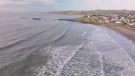 Olas-Haciendo-Espuma-Y-Aplastando-En-La-Playa-De-Arena-En-Cámara-Lenta,-Imágenes-Aéreas-Durante-La-Mañana-De-Invierno-En-Irlanda