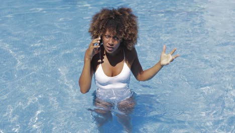mujer tirando el teléfono en la piscina