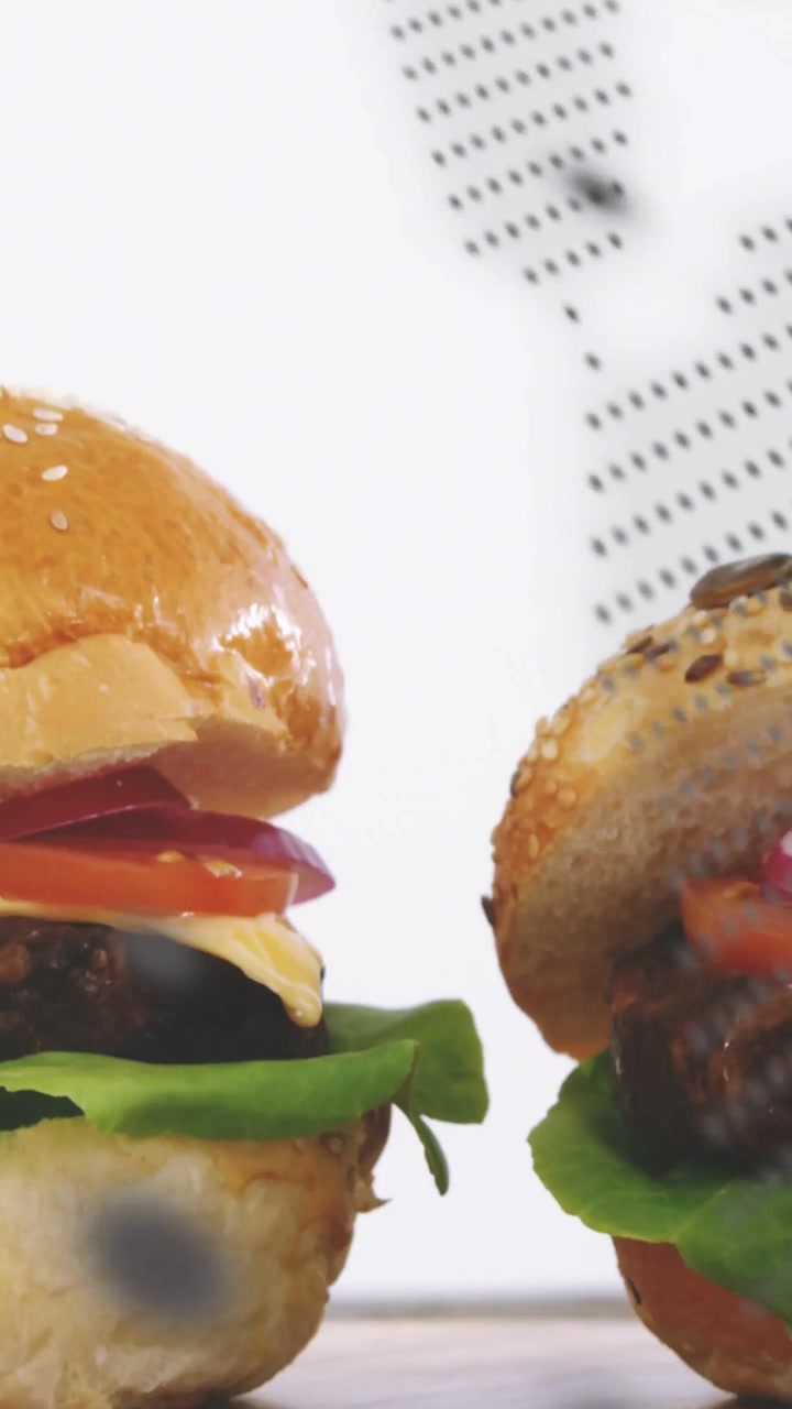 Video verticale: Un punto che scorre sovrapponendosi agli hamburger, con la telecamera che si muove e li centra per una pubblicità di cibo.