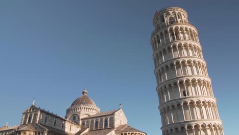 Noch-Schuss-Des-Schiefen-Turms-Von-Pisa-In-Der-Toskana-Mit-Drei-Vögeln,-Die-Nach-Links-Fliegen,-Goldene-Stunde,-Morgens-Klarer-Blauer-Himmel