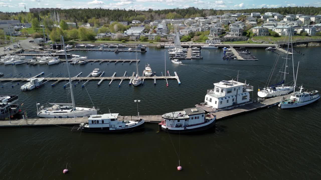 Aerial shot of a small motor boat docking in a small boat harbor.