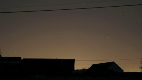 night sky time lapse with moving stars - barn outline in foreground