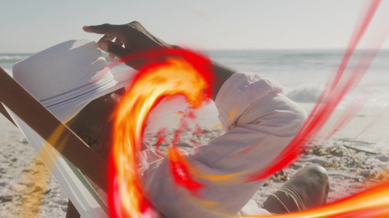 Man in chair shore, adjusting hat for travel while red swirl moving from right obscuring face