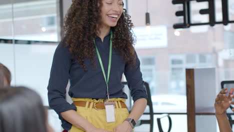 smiling businesswoman presenting to colleagues in modern office